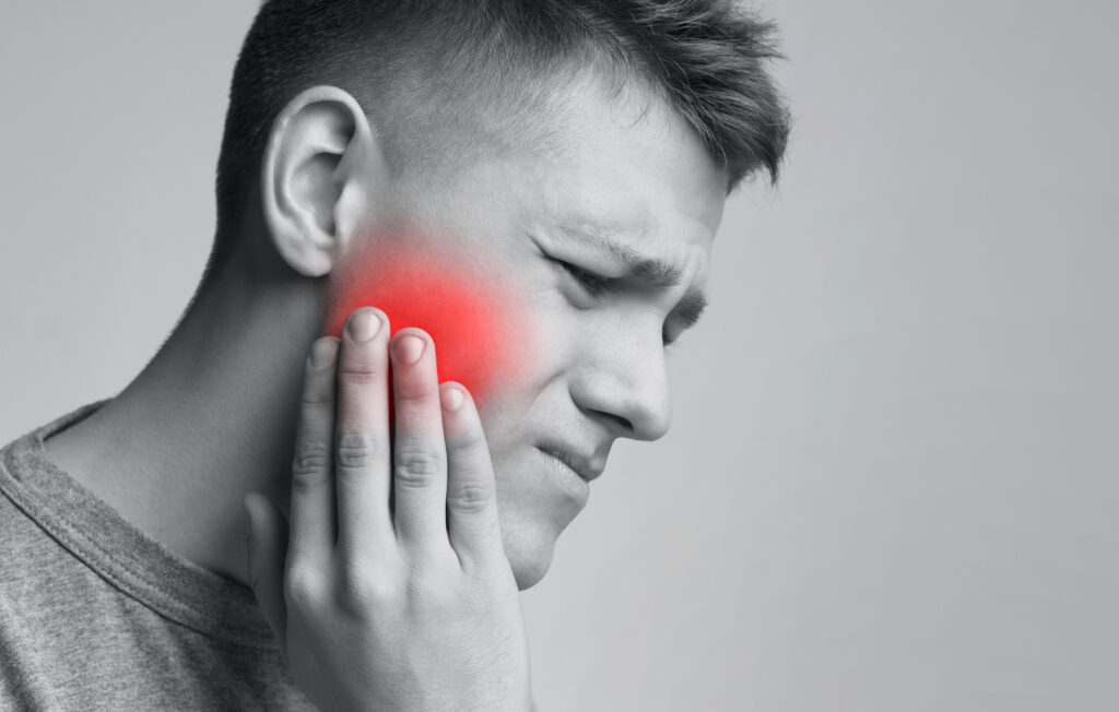 young man suffering from TMJ joint pain
