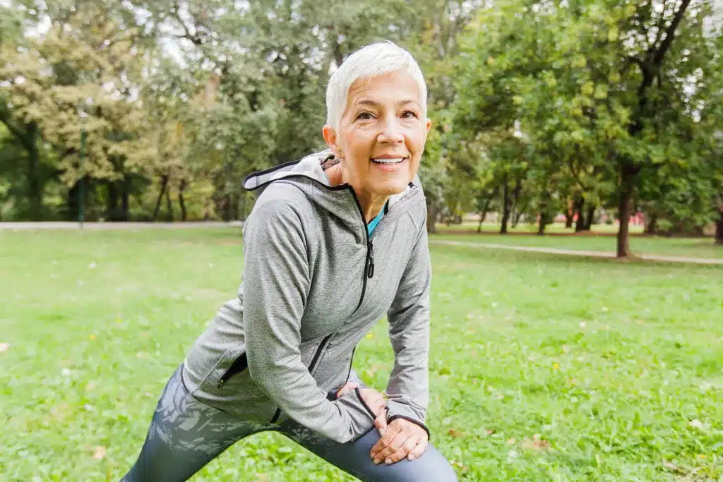 Woman staying active and healthy; Mature Fit Woman In Sportswear Doing Fitness Exercise In Nature, Workout Outdoor.